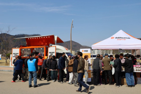▲3월 29일 빗썸나눔 임직원들이 영덕국민체육센터 앞에서 주민들에게 음식과 생필품 등 구호물품을 나누고 있다. (사진제공=빗썸나눔)