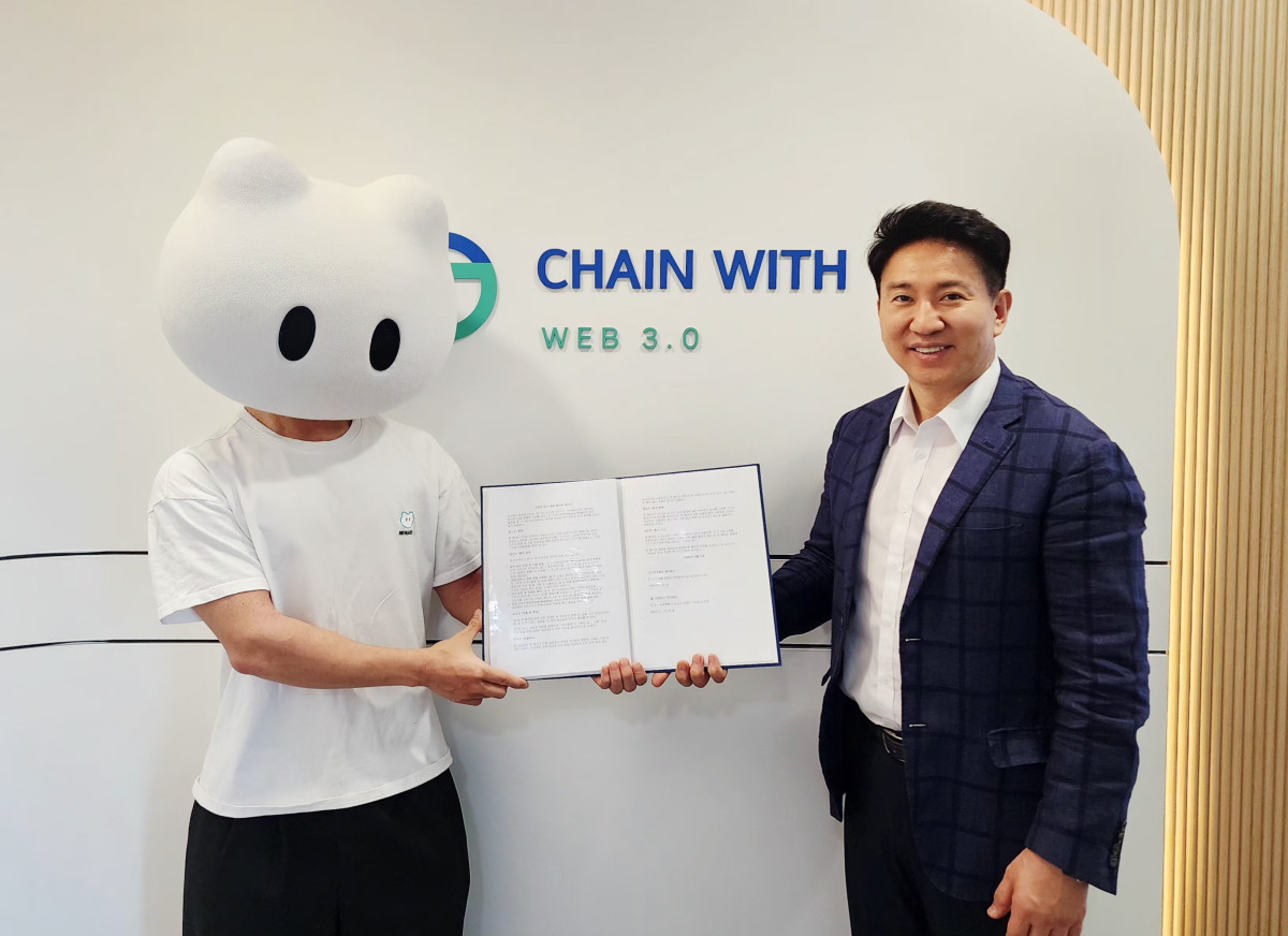 ▲리워디월렛 마스코트를 착용한 체인위드 전윤 대표(왼쪽)와 이카이스 이현준 대표가 전략적 업무제휴 체결 후 기념촬영을 하고 있다. (사진제공=체인위드)