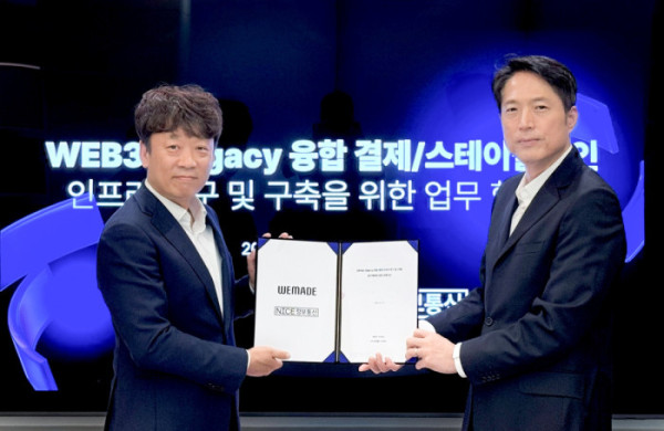 ▲웹3 결제 인프라 구축을 위한 업무협약(MOU) 체결식에서 강세현 NICE정보통신 스테이블코인 TFT 상무(왼쪽)와 김석환 위메이드 부사장이 기념촬영을 하고 있다. (사진제공=위메이드)